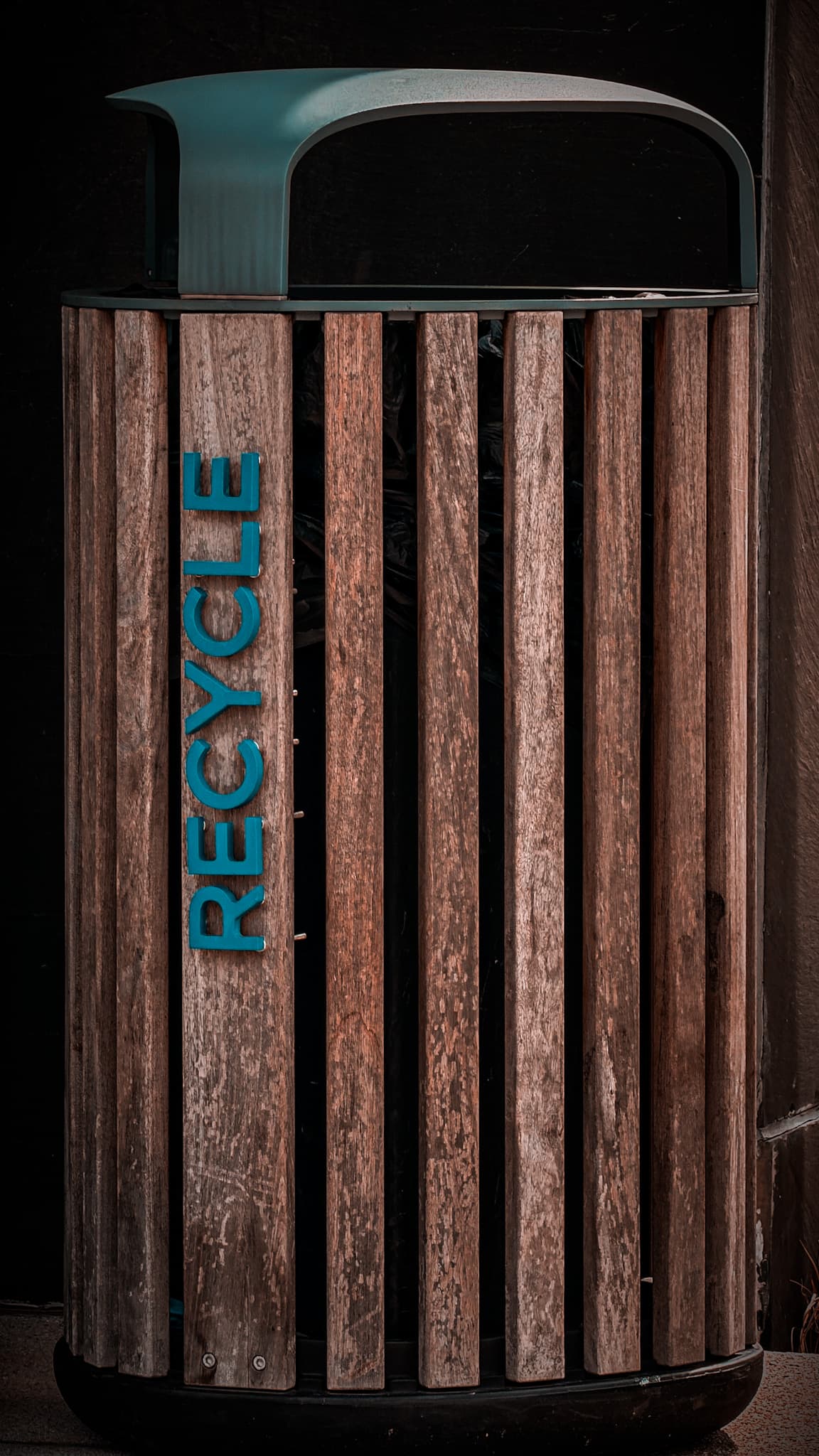 Wooden recycling bin outside A Wing with turquoise recycle lettering
