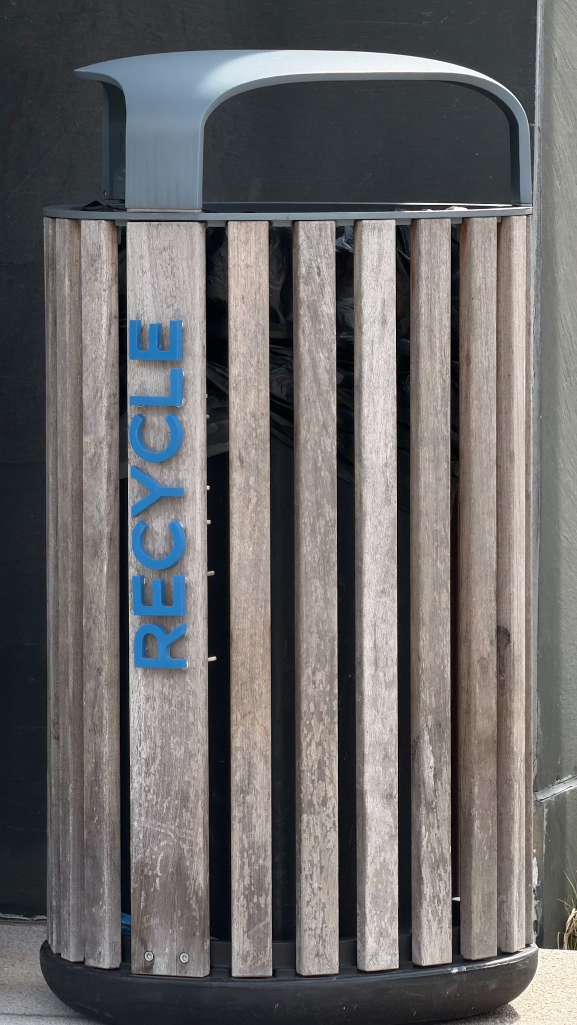 Unedited Wooden recycling bin outside A Wing with turquoise recycle lettering